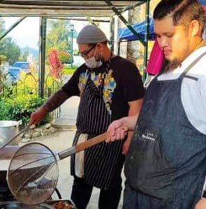 Wim Tabin (right) cooks for the volunteers during ECQ in Baguio City.